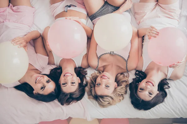 Top above high angle view of nice cute lovely attractive charming cheerful cheery optimistic girlfriends having fun lying on bed in light white interior decorated house — Stock Photo, Image