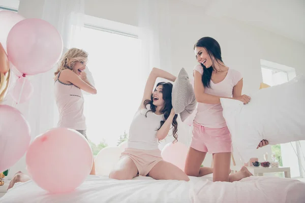 Nice attractive lovely fascinating adorable slim thin fit girlish feminine cheerful funny girlfriends sisters having fun attack battle contest rivalry in light white interior decorated house — Stock Photo, Image