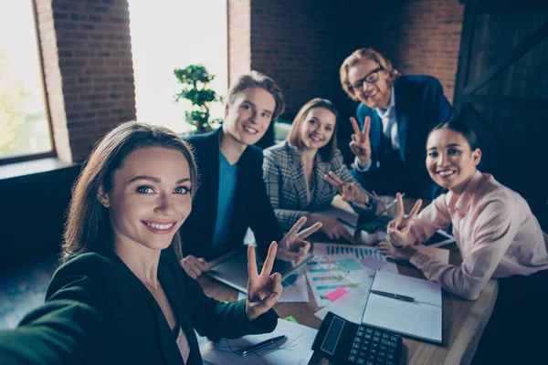 Autorretrato de bonito chic hermoso atractivo elegante moderno soñador elegante alegre alegre banqueros especialistas mostrando v-signo en la moderna estación de trabajo interior loft industrial — Foto de Stock