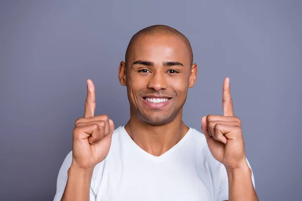 Närbild foto frisk maskulin mörk hud han honom hans macho flintskalle armar fingrar höjde upp till tomt utrymme Visa ny prislista bär vit t-shirt outfit kläder isolerade grå bakgrund — Stockfoto