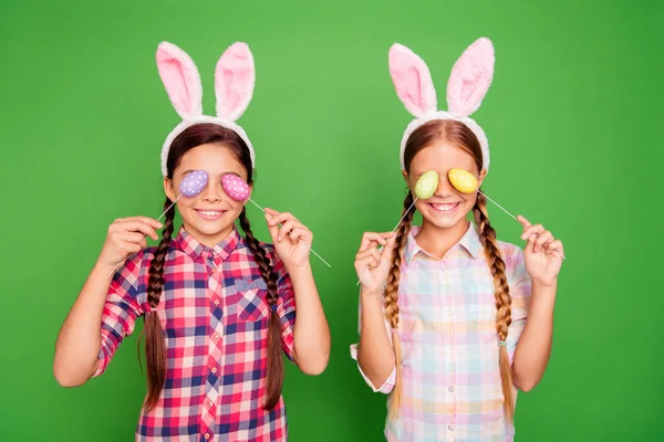 Portrét dvou pěkné rozkošný krásné vtipné veselé veselé pozitivní pre-dospívající dívky na sobě ověřil tričko zavírací oči s vejci svátek izolovaný jasný a intenzivní lesk zelené pozadí — Stock fotografie