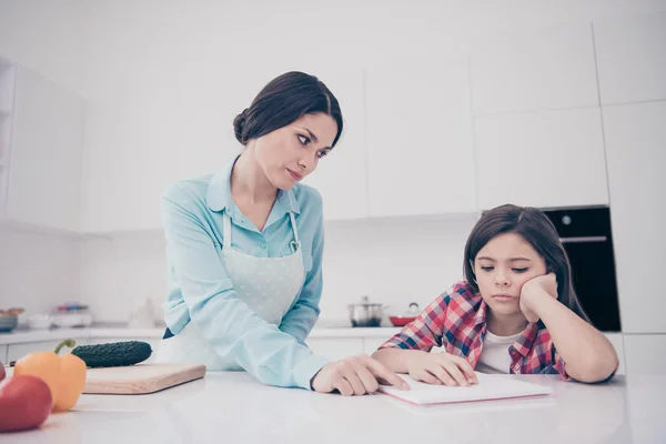 Retrato de dos lindos lindo atractivo concentrado concentrado molesto aburrido cansado gente madura mamá ayudar a chica haciendo cursos clases en luz blanca interior de la cocina en el interior — Foto de Stock