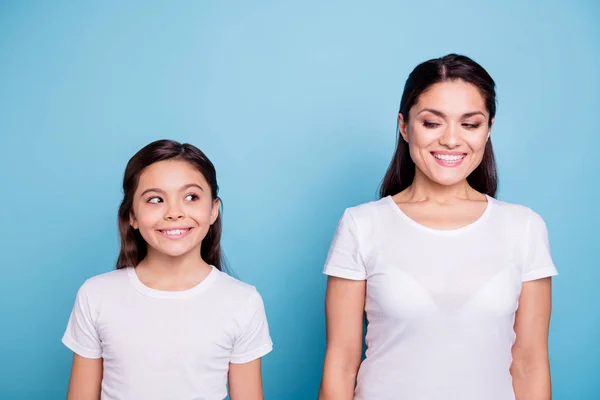 Närbild foto fantastiska ganska två personer Brun haired mamma och liten dotter står rakt inne sida varandra listiga klädd i vita t-shirts isolerad på ljusa blå bakgrund — Stockfoto