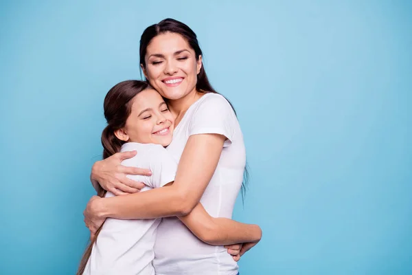 Close up photo adorable amazing two people brown haired mum small daughter eyes closed hold hands arms circle missed were separate wearing white t-shirts isolated bright blue background — стоковое фото