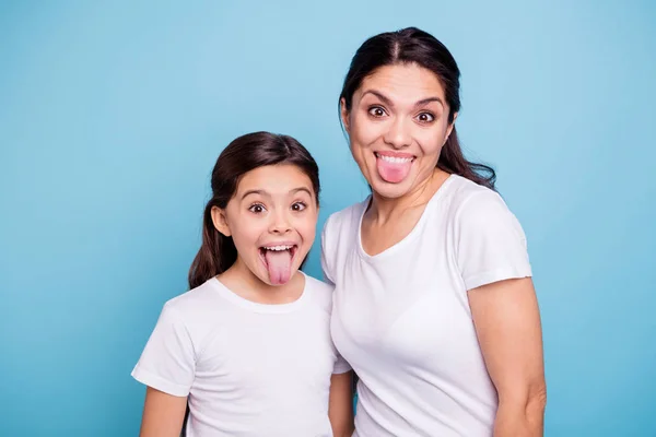 Närbild foto vackra två personer Brun haired mamma lilla dotter vänner hipsters fåniga mun öppnas tungan ut lurar runt spelar bära vita t-shirts isolerade ljusa blå bakgrund — Stockfoto