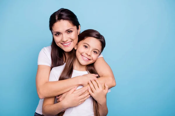 Close up photo amazing pretty two people brown haired mum mom small little daughter stand hugging piggy back lovely free time rejoice wearing white t-shirts isolated on bright blue background