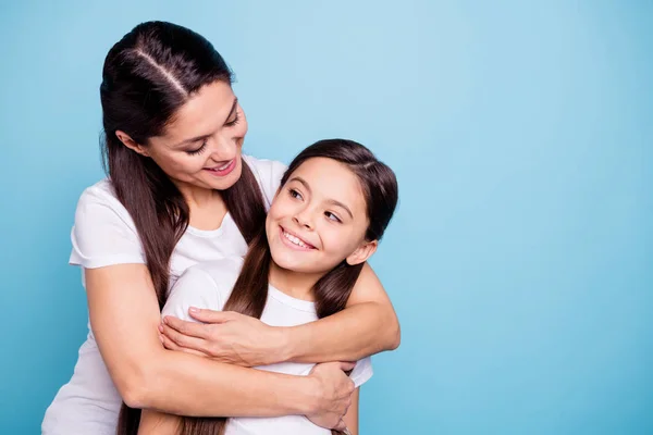 Close up photo pretty two people brown haired mum small daughter missed glad see each other stand hugging piggy back nice rejoice wearing white t@-@ shirts isolated on bright blue background — стоковое фото