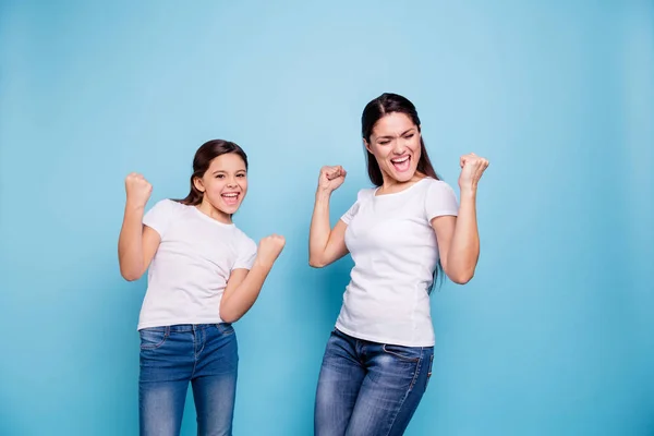 Primer plano foto alegría bonita dos personas de pelo castaño mamá pequeña hija brazos hasta en el aire con mucho gusto gritando consiguió venta libre descuento compras desgaste blanco camisetas aislado brillante fondo azul — Foto de Stock