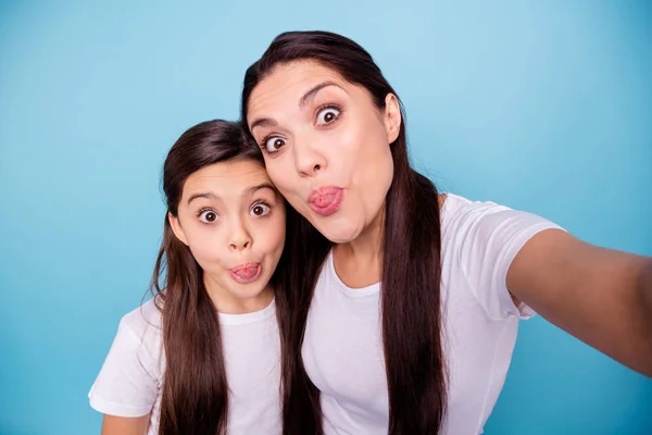 Close up fotografii úžasné krásné dva lidé hnědé vlasy maminka máma malá dceruška make Vezměte selfie jazyk z úst slámy potrubí tvar postava nosit bílé trička izolované světlé modré pozadí — Stock fotografie