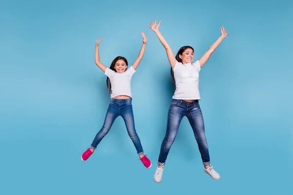 Full length body size view of two nice lovely attractive charming cheerful funny slim people in white t-shirt jeans denim raising hands up party isolated over blue pastel background — Stock Photo, Image