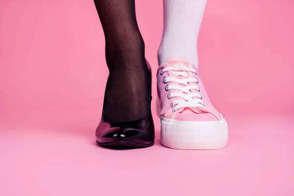 Beskurna närbild bild konceptet foto av två olika fit tunna smala ben cozy komfort lyx lyxigt elegant chic sportig jämförelse fotbeklädnad isolerad på rosa pastell bakgrund — Stockfoto