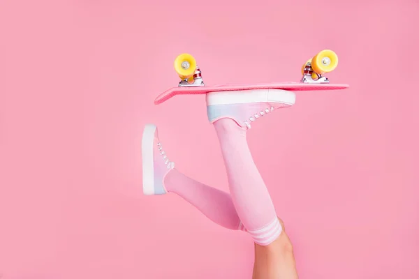Potongan dekat foto kurus ideal dia wanita kaki mengangkat memegang skateboard push dengan satu jari bergulir di udara penggemar terisolasi mawar merah muda latar belakang — Stok Foto
