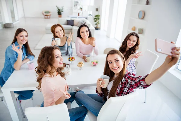 Cerca de retrato hermosa ella su diversidad damas sentarse mesa redonda blanca sostener tazas mostrar diferentes gestos hacer tomar selfies niñas día noche vacaciones en el interior — Foto de Stock
