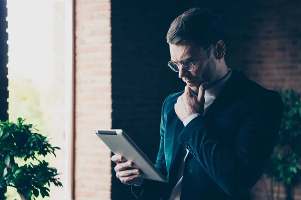 Porträtt av hans han trevlig stilig snygga trendiga smart smart kille marknadsförare pr manager specialist håller i händerna e-bok läser beter meddelande rapport på industriella loft interiör arbetsplatsen arbetsyta — Stockfoto