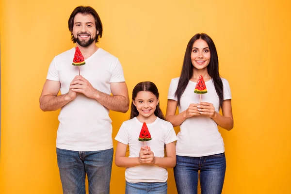 Porträt von netten süßen charmanten schönen attraktiven fröhlichen fröhlichen Menschen Papa Papa Mama Mama Mama hält in den Händen Bonbons isoliert über Glanz lebendigen pastellgelben Hintergrund — Stockfoto