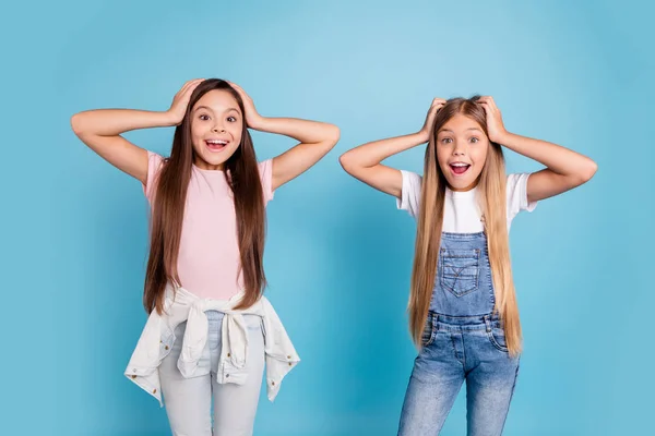 Retrato de dos personas agradable lindo sorprendido atractivo alegre divertido de pelo recto pre-adolescente niñas tocando cabeza grandes noticias wow fresco aislado sobre fondo pastel azul —  Fotos de Stock