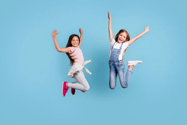 Full längd kropp storlek bild av två personer fina härliga attraktiva charmiga glada galna slarvig straight-haired pre-tonåring flickor jublar overjoy sval dag isoleras över blå pastell bakgrund — Stockfoto