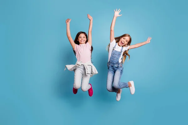 Full length body size view of two people attractive charming cheerful careless careless straight-haired pre-teen girls having fun party overjoy great weekend day isolated on blue pastel background — стоковое фото