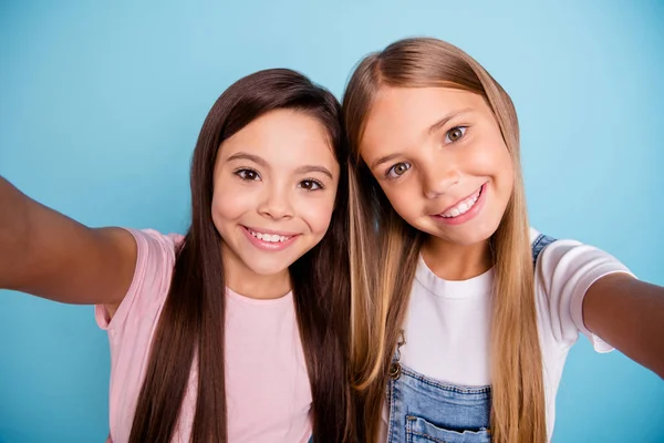 Self-portrait of two people nice-looking cute shine lovable lovely tender cheerful straight-haired pre-teen girls having fun day daydream free spare time isolated over blue pastel background