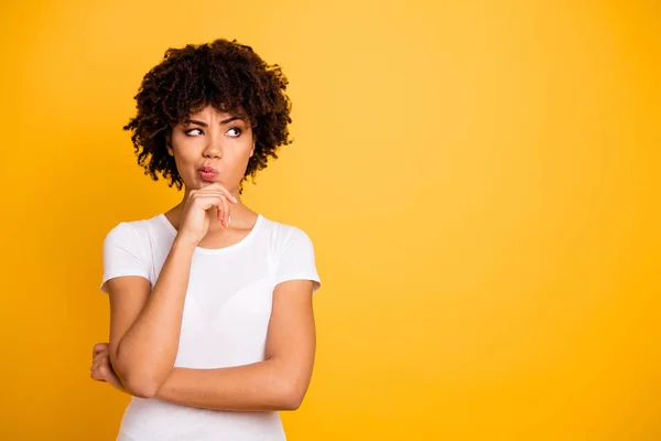 Close up photo beautiful amazed she her dark skin lady arms hands chin think over not sure homework diligent student look empty space wearing casual white t-shirt isolated yellow bright background — Stock Photo, Image