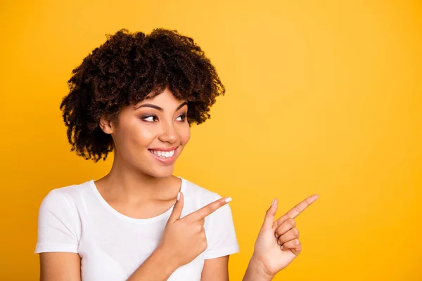 Retrato de cerca de ella ella agradable encantadora encantadora atractiva alegre alegre chica de pelo ondulado señalando dos dedos mirando a un lado espacio de copia aislado sobre brillante brillante brillo amarillo fondo —  Fotos de Stock