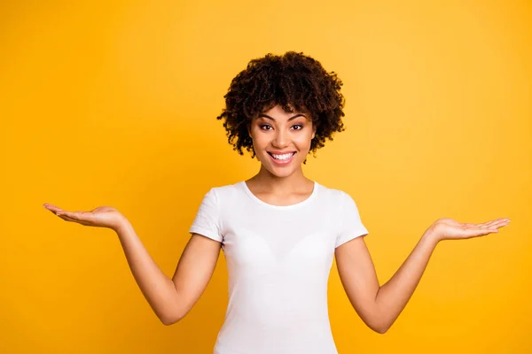 Retrato dela ela bonito bonito bonito bonito alegre alegre otimista menina de cabelos ondulados segurando duas palmas espaço de cópia isolado no brilhante brilho vívido fundo amarelo — Fotografia de Stock