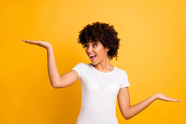 Retrato de ella ella agradable encantadora atractiva alegre alegre loca optimista chica de pelo ondulado sosteniendo dos palmas copia vacío espacio en blanco aislado sobre brillante brillante brillo amarillo fondo — Foto de Stock