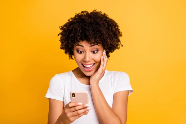 Close-up portrait of her she nice cute attractive lovely charming cheerful amazed wavy-haired lady holding in hands cell reading sms using new app 5g isolated on bright vivid shine yellow background