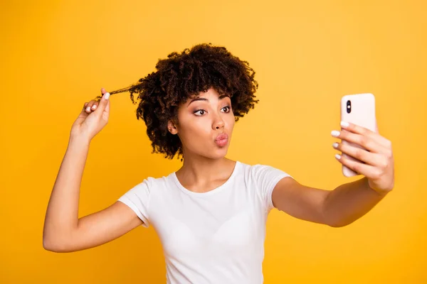 Primer plano retrato de ella ella bonita linda atractiva encantadora alegre divertida dama de pelo ondulado sosteniendo en las manos celda haciendo selfie tocar jugando con rizo aislado sobre brillante brillo vívido fondo amarillo — Foto de Stock