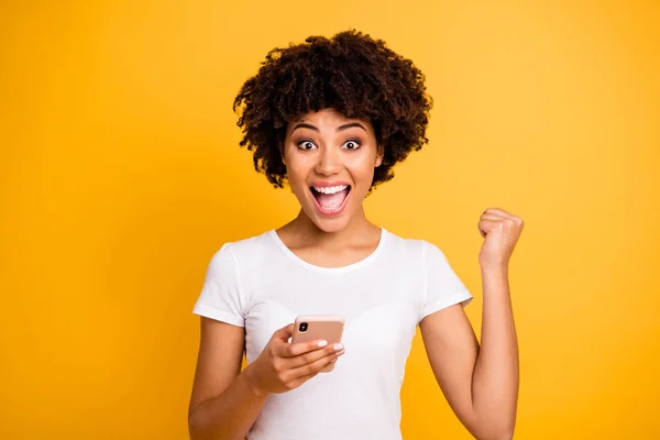 Retrato de ella ella agradable lindo atractivo encantador alegre alegre alegre alegre dama de pelo ondulado extático sosteniendo en la celda de las manos celebrando aislado en brillante brillo brillante fondo amarillo — Foto de Stock