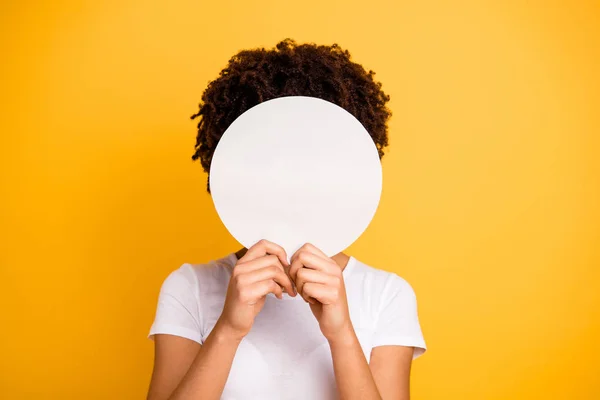 Stock image Close up photo beautiful amazing she her dark skin lady hiding face round circle banner placard do not want be recognized wear casual white t-shirt isolated yellow bright vibrant vivid background