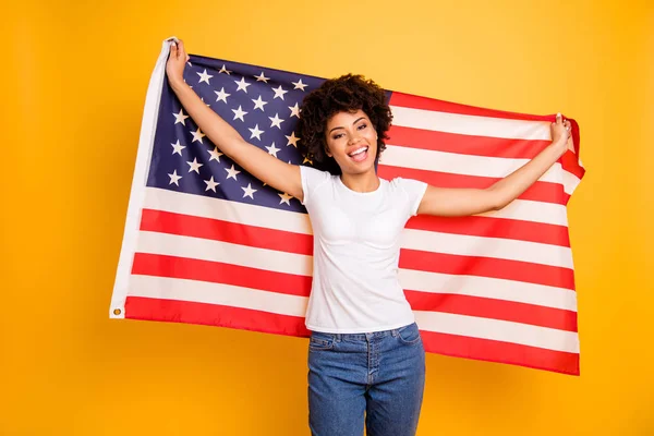 Närbild foto vacker fantastisk hon hennes mörka hud lady händer armar håller amerikansk flagga feststämning 4 juli bär casual jeans denim vit t-shirt isolerade gul ljusa levande bakgrund — Stockfoto