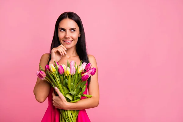 Portrét její ona roztomilá atraktivní krásné docela fascinující okouzlující veselá brunetka krasavice drží v rukou barevné květiny květinářství kousání rtů izolované na pastelově růžové pozadí — Stock fotografie