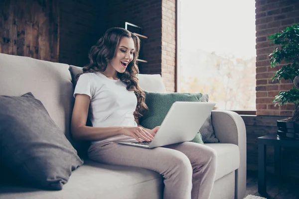 Close-up foto van kant profiel weergeven mooie brunette ze haar dame huisvrouw bekijken serie seriële tv Toon notebook geschokt definitieve dragen van binnenlandse lichte kleur t-shirt kleding outfit sit comfortabele divan — Stockfoto