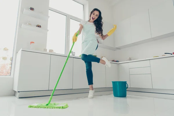 Full length body size side profile photo beautiful cheerful hardworking duties she her lady house love clean dancing singing wear jeans casual t-shirt covered cute apron bright light kitchen — стоковое фото