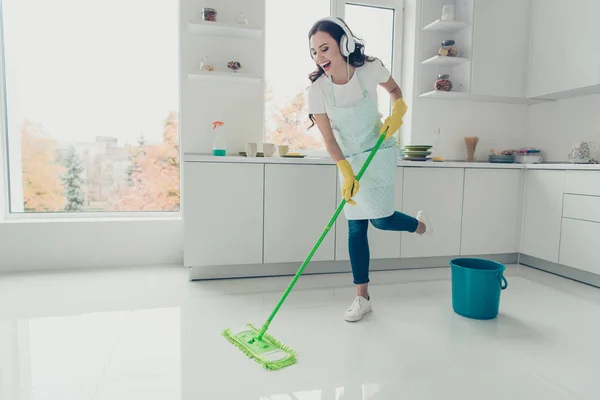 Volle Länge Körpergröße Seitenprofil Foto schön fleißig Aufgaben sie ihre Dame Haus tanzen singen Ohrenklappen auf dem Kopf tragen Jeans Denim lässig T-Shirt bedeckt niedlich Schürze hell Licht Küche — Stockfoto