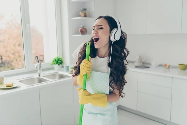 Porträt von ihr sie schöne schöne schöne charmante weinselige Hausfrau mit Besen wie Mikrofon singen populäre Lieder in modernen hellweißen Interieur drinnen — Stockfoto