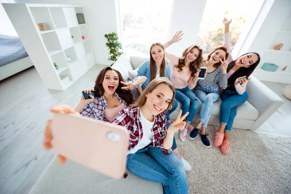 Close up photo cheerful beautiful she her ladies big family roommates telephone show v-sign say hi having fun best buddies make take selfies excited amazed bright white room girls day indoors — стоковое фото