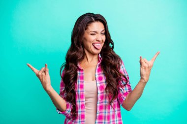 Close up photo beautiful tongue out mouth she her lady hands arms metal music lover symbol ready rock concert wearing casual plaid checkered pink shirt outfit isolated teal bright vivid background clipart