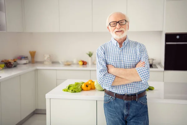 Närbild porträtt grå korthårig han hans honom morfar armar korsade lutande matlagning tabell uppriktigt leende bär specifikationer casual rutig Pläd skjorta jeans denim outfit stå ljust ljus kök rum — Stockfoto