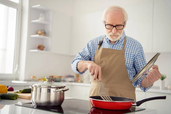 Detailní záběr fotografie šedé vlasy mu jeho mu děda cook jídlo fritovací, vařící zaneprázdněn vynikající hrnce pozorně míchání otáčení opotřebení specifikace ležérní kostkovaná kostkované košile džíny denim oblečení kuchyně — Stock fotografie