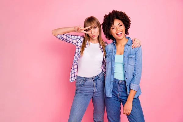 Close-up foto twee funky diversiteit ze haar dames ander ras speelse verzenden kus knuffel omhelzing knuffel Toon v-sign oog slijtage casual jeans denim geruit overhemd kleding outfit geïsoleerde roze achtergrond — Stockfoto