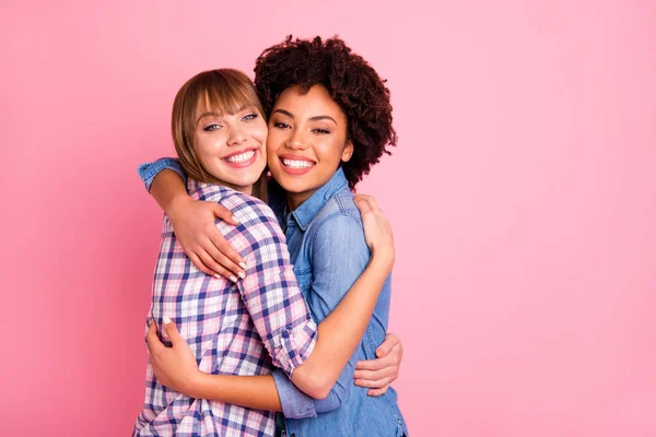 Close up photo two mindless diversity she her ladies hold each other close missed I have not seen for ages concept wear casual jeans checkered shirt clothes outfit isolated pink background — стоковое фото