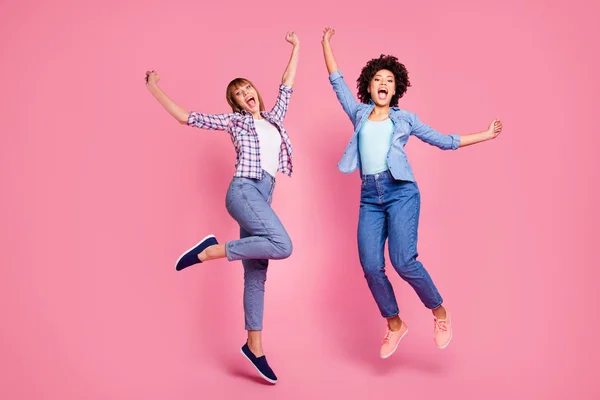 Longitud completa tamaño corporal vista de dos personas de aspecto agradable encantadora alegre alegre alegre niñas volando regocijo aislado sobre rosa pastel fondo — Foto de Stock