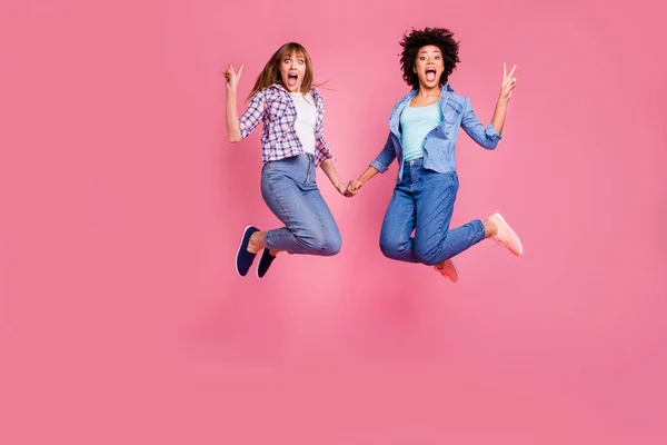 Longitud completa cuerpo tamaño vista de dos personas agradable atractivo alegre divertido divertido loco funky niñas cogidas de la mano mostrando v-signo aislado sobre rosa pastel fondo — Foto de Stock