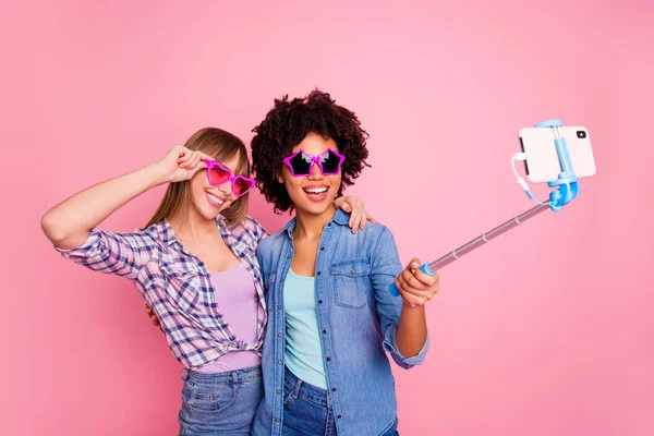 Retrato de dos personas agradable fresco atractivo encantador alegre alegre niñas usando casual a cuadros camisa toma selfie día de verano aislado sobre rosa pastel fondo —  Fotos de Stock