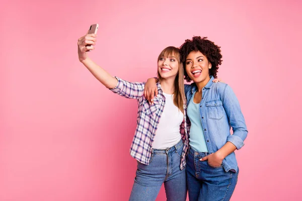 Portrait of two person nice cute lovely friendly attractive charming cheerful girls wearing casual checkered shirt making taking selfie day isolated over pink pastel background