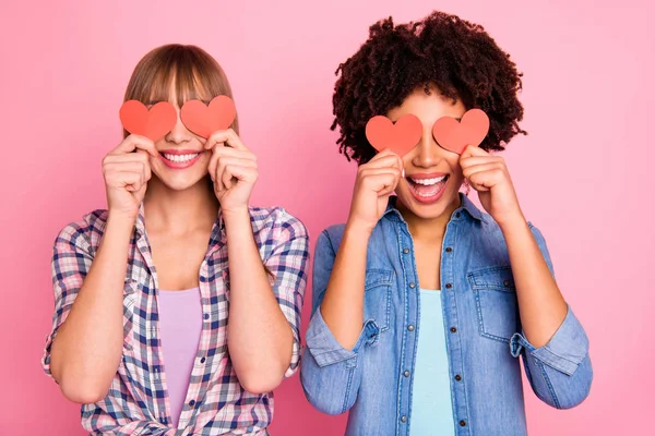Close-up retrato de duas pessoas agradável agradável doce encantador encantador alegre meninas alegres em xadrez camisa fechar cobrindo os olhos com pequenos cartões isolados sobre fundo pastel rosa — Fotografia de Stock