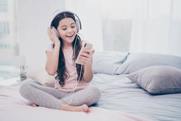 Närbild foto söt vacker hon hennes lilla flicka smart telefon händer öronlappar Läs text nya populära låt lockigt vågiga slitage hem t-shirt byxor bekväma lägenheter platt ljus färgad rum — Stockfoto