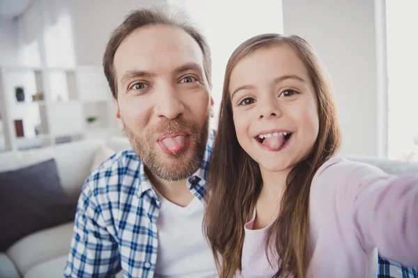 Self-portrait of his he her she nice cute attractive cheerful cheery positive foolish pre-teen girl bearded dad daddy showing tongue out in light white interior room indoors — Stock Photo, Image